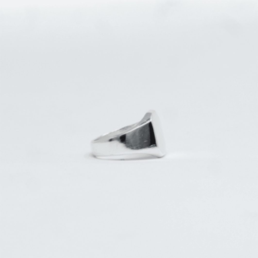 Second plan du bijou, de la bague Chevaliere SANU Argent en argent veritable 925, signe WB Paris (Westaff Bijouterie). Anneau au galbe net, tour de doigt ajuste, port au doigt ; on remarque la patine durable et les reflets nets du metal. Modele personnalisable : gravure prenom, date ou initiales. Style moderne, ideal femme — idee cadeau. Recherches : argent sterling, bijou argent, idee cadeau, pas cher. Argent 925 hypoallergenique. Mot-cle : argent massif.
