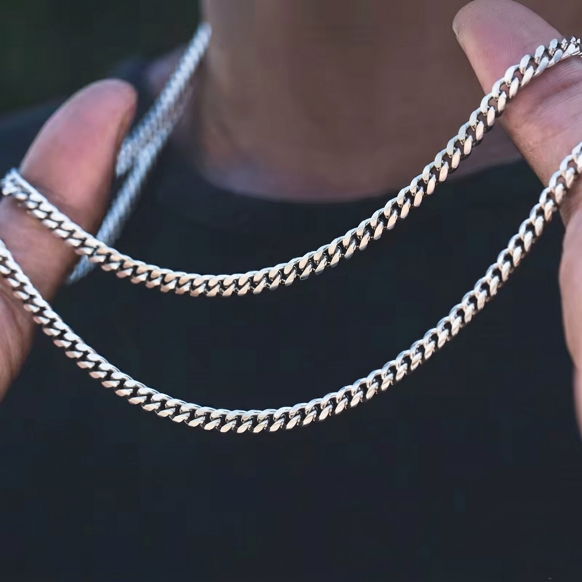 Vue lifestyle portee, du collier CUBAIN (ARGENT) 10MM en acier inox argente, signe WB Paris (Westaff Bijouterie). Chaine aux maillons reguliers, port au cou ; on remarque la finition lisse sans asperite et les reflets nets du metal. Presente sur un modele, la photo donne l'echelle reelle et le rendu au porter. Style elegant, ideal mixte — a porter au quotidien. Recherches : acier inoxydable, chaine acier homme, a porter au quotidien, fabrication soignee.